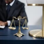 Elegant legal office with a close-up of golden scales of justice on a sleek dark desk.